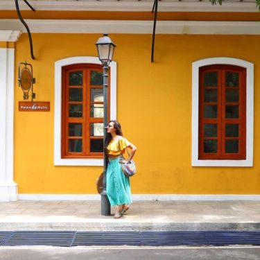 girl posing in white town pondicherry in front of yellow walls Palais de Male and Franco indian architecture
